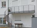 Balkon mit Wendeltreppen und Holzstufen